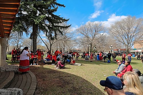 Crowd listens to an Indigenous woman's story at the Sunday march from Brandon City Hall to Princess Park in honour of Red Dress Day. (Charlotte McConkey/The Brandon Sun)