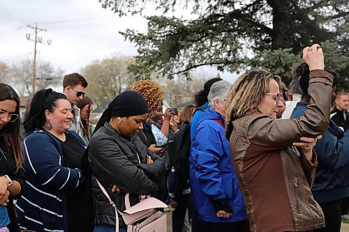 The crowd of churchgoers pray together before entering the new facility. (Charlotte McConkey/The Brandon Sun)