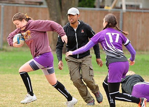 Vincent Massey Vikings girls' rugby assistant coach Jerome Cruz has an attentive audience during pre-game training sessions, here working on ball passing and tackling to set up a ruck. (Jules Xavier/The Brandon Sun)