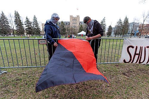 MIKE DEAL / FREE PRESS
Protesters hang a anarcho-communist flag on the security fence.
Students for Justice in Palestine, a group at the University of Manitoba, set up an encampment in solidarity with the Palestinian people in Gaza in the quad at the Fort Garry campus Tuesday morning. The encampment will run from 9 a.m. to 11 p.m. for the next three days.
See Tyler Searle story
240507 - Tuesday, May 07, 2024.