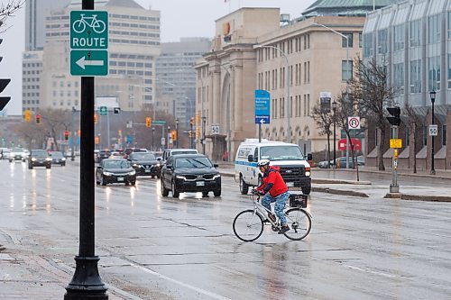 MIKE DEAL / FREE PRESS
A cyclist crosses Main Street at Assiniboine Avenue. There is a report at the public works meeting on Tuesday on closing part of Assiniboine to traffic for a pilot project.

240507 - Tuesday, May 07, 2024.