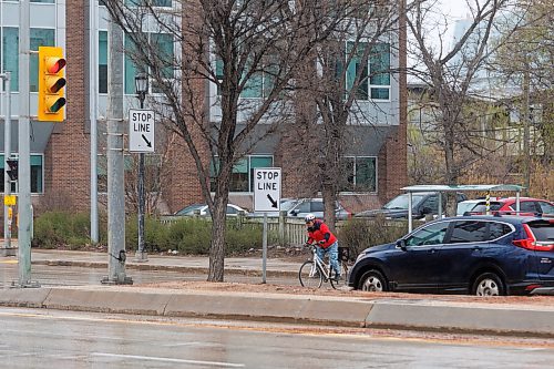 MIKE DEAL / FREE PRESS
A cyclist crosses Main Street at Assiniboine Avenue. There is a report at the public works meeting on Tuesday on closing part of Assiniboine to traffic for a pilot project.

240507 - Tuesday, May 07, 2024.