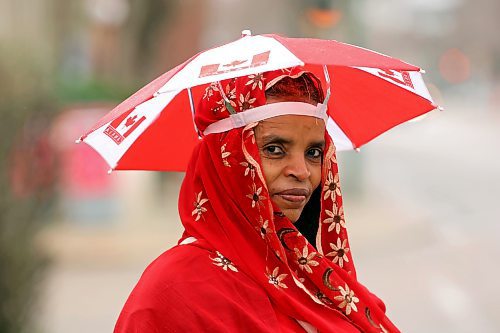 07052024
Atsdee Ygizaw stays dry under an umbrella hat that matches the rest of her outfit while waiting for a bus on Princess Avenue on a rainy Tuesday.
(Tim Smith/The Brandon Sun)