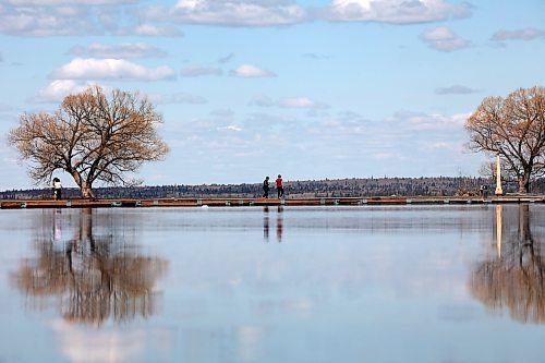 Visitors to Riding Mountain National Park walk along the Clear Lake pier in Wasagaming on a calm and sunny Thursday. While all watercraft are banned from the lake this summer, swimming and angling is still permitted. (Tim Smith/The Brandon Sun)