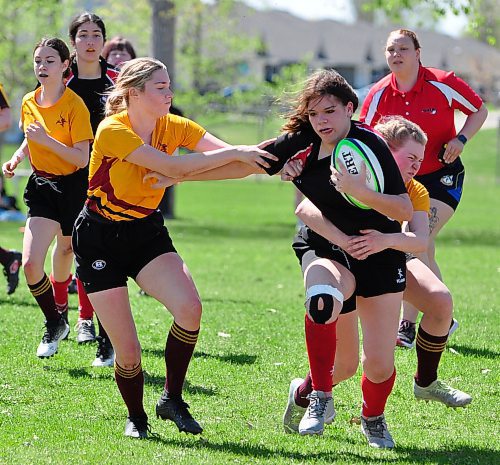 Future Brandon University Bobcats rugby teammates starting this fall, Crocus Plainsmen back field players Charli Merckx (left) and Ocean Kominshin-Glass work together to tackle a Swan Valley opponent during their Friday afternoon game. (Jules Xavier/The Brandon Sun)