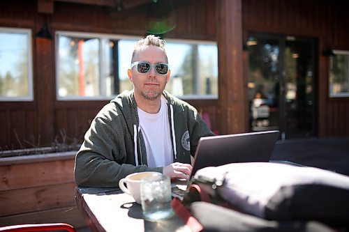 Christian Robin, president of the Clear Lake Cabin Owners Association, works at a table on the patio of The Lakehouse restaurant in Wasagaming on Friday.  (Tim Smith/The Brandon Sun)