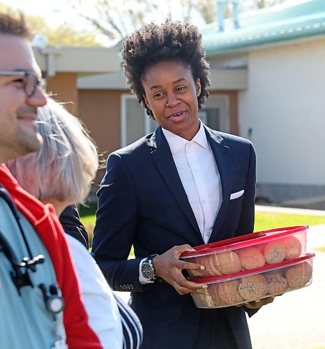 Manitoba Health Minister Uzoma Asagwara holds two large containers of cookies given by  Carberry Health Action Committee member and health care worker Loretta Oliver, who promised the premier and his ministers a hug and cookies if the government was successful in reopening the Carberry Health Centre's emergency room. Premier Wab Kinew and Minister Asagwara announced the ER's reopening to strong applause on Friday morning in Carberry. (Matt Goerzen/The Brandon Sun)