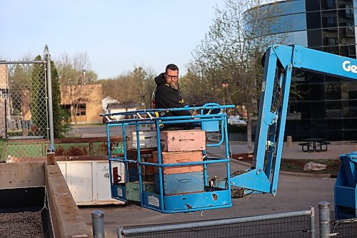 Trevor Kalinowich of BU's physical plant controls the boom lifting the beehives to the roof of Knowles Douglas Centre on Saturday. (Photos by Abiola Odutola/The Brandon Sun)