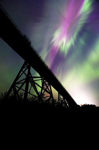 The iconic railway trestle at Rivers, Man. is silhouetted against the pink, yellow, purple and green hues of a particularly strong aurora borealis early Sunday morning. (Matt Goerzen/The Brandon Sun)