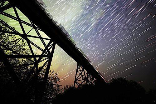 The waning colours of the aurora borealis brighten the night sky over Rivers, MB and it's iconic railway trestle early Sunday morning. This star trails picture was created using a collection of 138 separate long exposure images of 10 seconds each that have been stacked together using a computer program. (Matt Goerzen/The Brandon Sun)