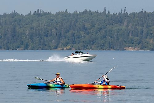 Kayakers paddle through the cool water of Clear Lake while a boat passes behind them in Riding Mountain National Park on a hot Thursday in 2023. Scenes like this will not take place this summer as the federal government has banned boats from Clear Lake for the 2024 season. 
(Tim Smith/The Brandon Sun)