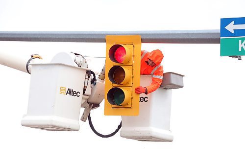 Kevin Pich, a traffic signals technician with Manitoba Transportation and Infrastructure, inspects a traffic signal at the intersection of First Street and Kirkcaldy Drive on a cool and rainy Tuesday afternoon. The provincial highways team will be in Brandon inspecting traffic signals on provincial roads this week. (Matt Goerzen/The Brandon Sun)