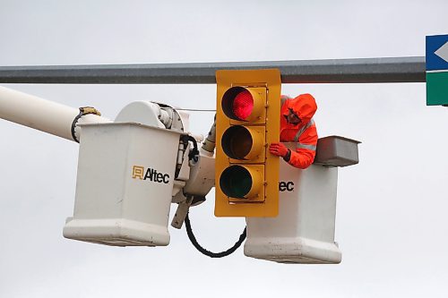 Kevin Pich, a traffic signals technician with Manitoba Transportation and Infrastructure, inspects a traffic signal at the intersection of First Street and Kirkcaldy Drive on a cool and rainy Tuesday afternoon. The provincial highways team will be in Brandon inspecting traffic signals on provincial roads this week. (Matt Goerzen/The Brandon Sun)