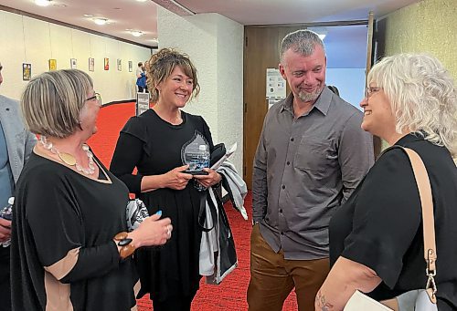 Tanya LaBuick accepts congratulations from friends after winning the Women of Distinction award Wednesday evening at the Western Manitoba Centennial Auditorium for her contributions to community leadership and social action. Also pictured are (from left) Louise Lamont, Bart Curtis (LaBuick's business partner) and Sue Swarvrick. (Michele McDougall/The Brandon Sun)