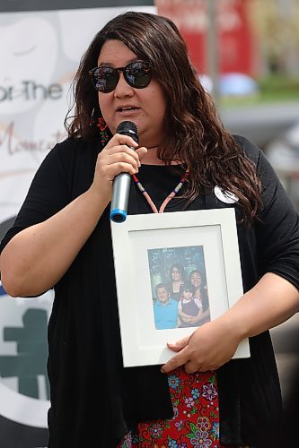 Natashia Marion, an Indigenous Community Coordinator with the Brandon Urban Aboriginal Peoples' Council, holds a picture of the women in her family while addressing participans in the Moose Hide Campaign march from Princess Park on Thursday afternoon. (Matt Goerzen/The Brandon Sun)