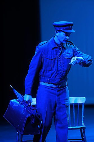 Moir enters the stage looking at his watch under a blue light during the opening scene of Padr X. (Matt Goerzen/The Brandon Sun)