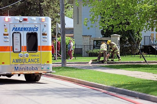 Brandon Fire and Emergency Services members attach a hose to a hydrant as they prepare to tackle a backyard shed fire near the intersection of 12th St. North and Stickney Avenue on Sunday afternoon. (Colin Slark/The Brandon Sun)