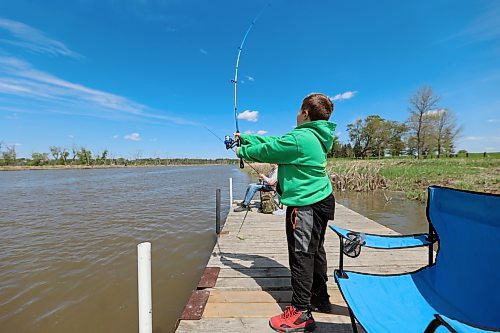 Quin Longworth casts a fishing line into the Assiniboine River on a sunny Sunday afternoon in Dinsdale Park as brother Dane keeps a close eye on his own. (Colin Slark/The Brandon Sun)