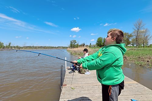 Quin Longworth casts a fishing line into the Assiniboine River on a sunny Sunday afternoon in Dinsdale Park as brother Dane keeps a close eye on his own. (Colin Slark/The Brandon Sun)