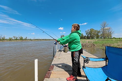 Quin Longworth casts a fishing line into the Assiniboine River on a sunny Sunday afternoon in Dinsdale Park as brother Dane keeps a close eye on his own. (Colin Slark/The Brandon Sun)