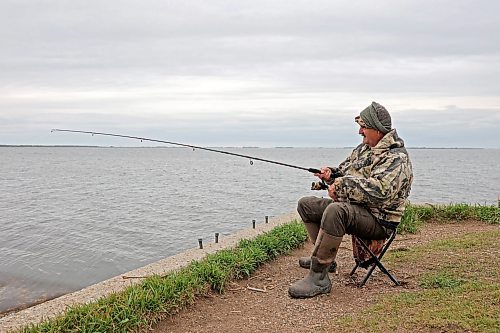 Mike Ketcheson of Brandon fishes at Oak Lake on a windy Thursday afternoon. Ketcheson tries to get out fishing throughout western Manitoba every few days, year round and spent Thursday catching northern pike and pickerel. 
(Tim Smith/The Brandon Sun)