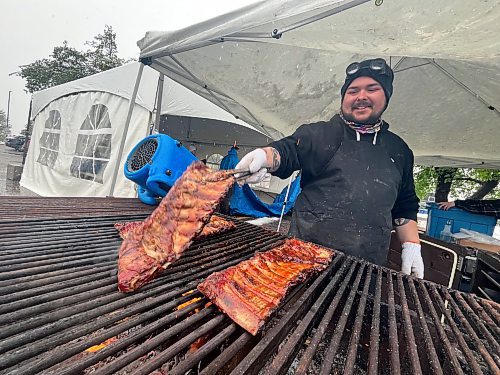 Brad Bosence, a griller with Buckeye BBQ and the Western Canada Rib Fest Tour, grills a few racks of ribs on a cold and wet Friday afternoon. (Matt Goerzen/The Brandon Sun)