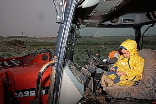 24052024
Five-year-old Blake Kowbel watches Lego videos on a phone from the warmth of a tractor cab as his parents Nathan and Kate Kowbel tie fence for cattle in a field along Highway 10 near their farm north of Brandon during flurries on a wet, snowy and cool Friday. The Kowbel's grow crops in addition to raising cattle and have seeded about 800 acres so far this season but their seeding has been slowed by recent wet weather. 
(Tim Smith/The Brandon Sun)