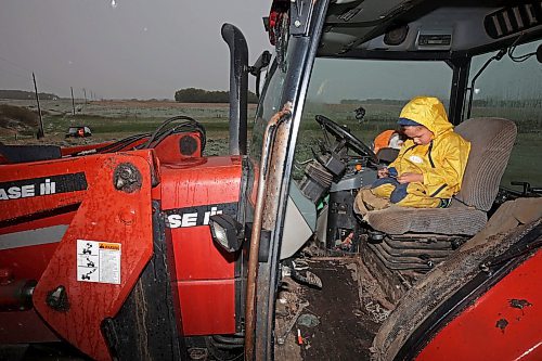 24052024
Five-year-old Blake Kowbel watches Lego videos on a phone from the warmth of a tractor cab as his parents Nathan and Kate Kowbel tie fence for cattle in a field along Highway 10 near their farm north of Brandon during flurries on a wet, snowy and cool Friday. The Kowbel's grow crops in addition to raising cattle and have seeded about 800 acres so far this season but their seeding has been slowed by recent wet weather. 
(Tim Smith/The Brandon Sun)