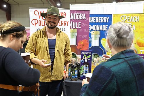  A happy vendor makes a sale of a bottle of Manitoba Honeyberry vodka from Winnipeg's Capital K Distillery during the Apple and Pine Market held in the Manitoba Room at the Keystone Centre on Saturday. (Michele McDougall/The Brandon Sun)