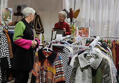 A customer looks in the mirror as she tries on a handmade coat during the Apple and Pine Market held in the Manitoba Room at the Keystone Centre on Saturday. (Michele McDougall/The Brandon Sun)
