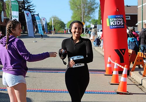 Brooklyn Paddock receives a medal as she crosses the finish line, after running the 5K timed event in 26 minutes during the 45th annual YMCA Strong Kids Run on Sunday that started and ended in downtown Brandon. (Michele McDougall/The Brandon Sun)  