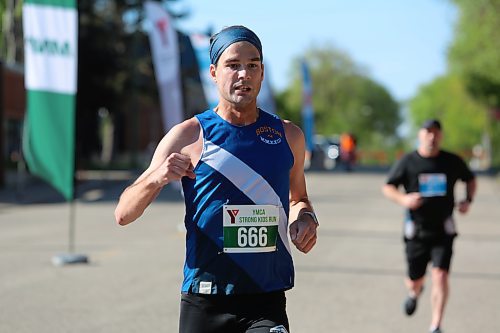 Brandon's Trent Gill makes a celebratory fist as he crosses the finish line after winning the 20K timed event during the 45th annual YMCA Strong Kids Run on Sunday that started and ended in downtown Brandon. (Michele McDougall/The Brandon Sun)  