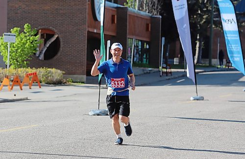 A runner waves to the welcoming crowd as he nears the finish line during the 45th annual YMCA Strong Kids Run on Sunday that started and ended in downtown Brandon. (Michele McDougall/The Brandon Sun)  