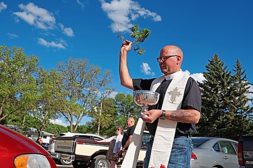 30052024
Father Chris Arthur with Redeemer-St. George’s Church in Brandon blesses cars during The Road Rebels Blessing of the Wheels Car Show on Thursday evening. The event included a BBQ with proceeds going to the Anglican Memorial Camp. Local car enthusiasts brought their cars to be blessed.
(Tim Smith/The Brandon Sun)