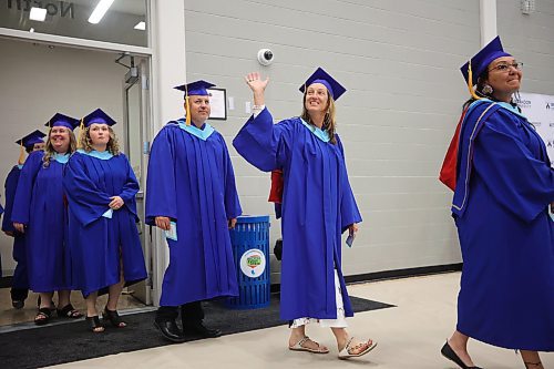 A graduate waves to supporters in the crowd while entering Brandon University’s convocation for the faculty of education on Thursday afternoon. (Tim Smith/The Brandon Sun)