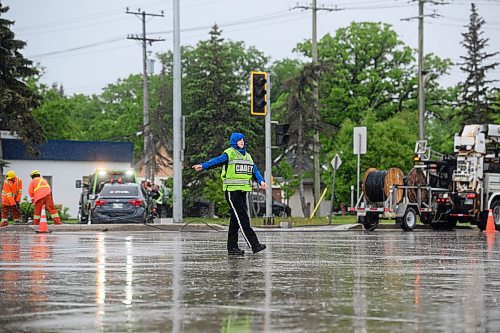 Mike Sudoma/Free Press
WPS and Cadets members direct traffic in the rain while Manitoba Hydro workers fix a traffic light that was rinvolved in a collision with a car earlier Thursday afternoon
May 30, 2024