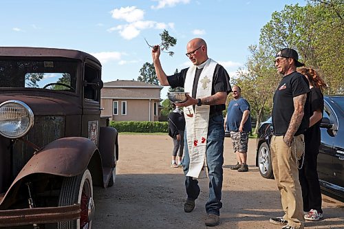 30052024
Father Chris Arthur with Redeemer-St. George&#x2019;s Church in Brandon blesses Curt Stauffer&#x2019;s 1932 Ford truck during The Road Rebels Blessing of the Wheels Car Show on Thursday evening. The event included a BBQ with proceeds going to the Anglican Memorial Camp. Local car enthusiasts brought their cars to be blessed.
(Tim Smith/The Brandon Sun)