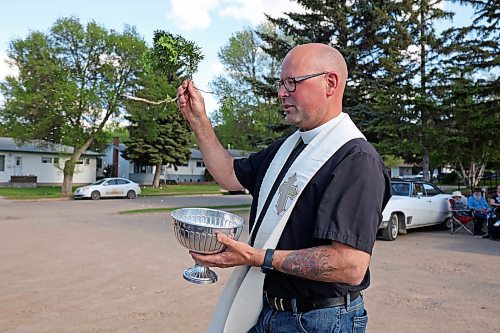 30052024
Father Chris Arthur with Redeemer-St. George&#x2019;s Church in Brandon blesses cars during The Road Rebels Blessing of the Wheels Car Show on Thursday evening. The event included a BBQ with proceeds going to the Anglican Memorial Camp. Local car enthusiasts brought their cars to be blessed.
(Tim Smith/The Brandon Sun)