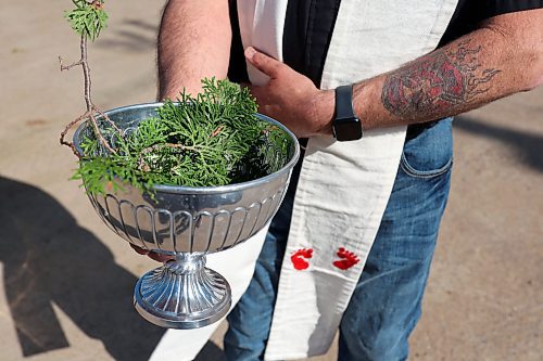 30052024
Father Chris Arthur with Redeemer-St. George&#x2019;s Church in Brandon holds a bowl with holy water during The Road Rebels Blessing of the Wheels Car Show on Thursday evening. The event included a BBQ with proceeds going to the Anglican Memorial Camp. Local car enthusiasts brought their cars to be blessed.
(Tim Smith/The Brandon Sun)