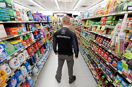 MIKE DEAL / FREE PRESS ILLUSTRATION 
An Impact Security guard walks down a grocery isle.
240531 - Friday, May 31, 2024.