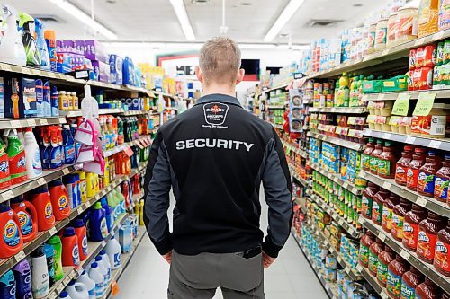 MIKE DEAL / FREE PRESS ILLUSTRATION 
An Impact Security guard walks down a grocery isle.
240531 - Friday, May 31, 2024.