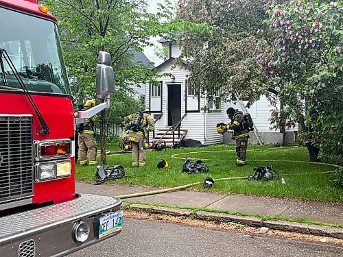 A fire truck and other emergency vehicles block access to the 300 block of 16th Street while firefighters attempt to douse a house fire on Tuesday morning. (Matt Goerzen/The Brandon Sun)