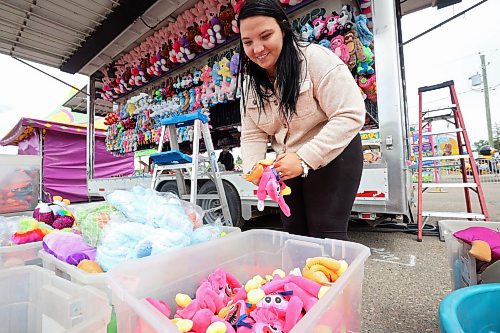 04062024
Kenzie Wiese sets up prizes for the duck pond midway game in preparation for the opening day of the Manitoba Summer Fair at the Keystone Centre grounds on Tuesday. The annual fair opens this afternoon and runs until Sunday. 
(Tim Smith/The Brandon Sun)