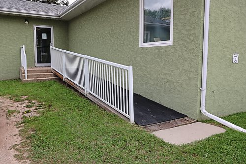 The library's ramp is around the back of the facility. To get to it, strollers and wheelchairs need to go through grass and gravel. Increasing accessibility is one of the things library employee Krista Law would like to see. (Charlotte McConkey/The Brandon Sun)