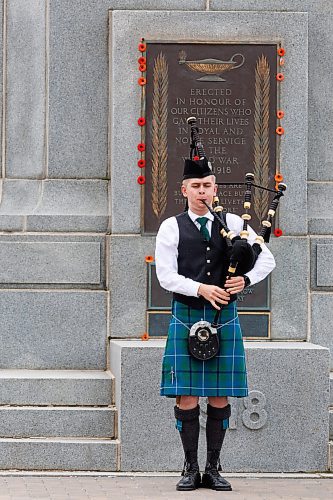 MIKE DEAL / FREE PRESS
Ethan Blain, Pipe Major of the Lord Selkirk Robert Fraser Memorial Pipe Band, in front of the Cenotaph on Memorial Boulevard, performs with his bagpipes in memory of the Normandy Landings of D-Day that took place 80 years ago on June 6th, 1944. 
240606 - Thursday, June 06, 2024.