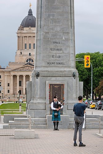 MIKE DEAL / FREE PRESS
Ethan Blain, Pipe Major of the Lord Selkirk Robert Fraser Memorial Pipe Band, in front of the Cenotaph on Memorial Boulevard, performs with his bagpipes in memory of the Normandy Landings of D-Day that took place 80 years ago on June 6th, 1944. 
240606 - Thursday, June 06, 2024.