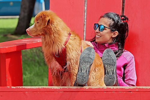 06062024
Parisa Jiwa sits in an oversized Adirondack chair with her dog Ender while visiting Wasagaming in Riding Mountain National Park from Calgary with family on Thursday. 
(Tim Smith/The Brandon Sun)