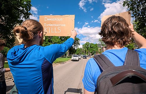 Mike Sudoma/Free Press
Two cycling advocates hold up signs on the front lines of a blockade Friday afternoon The blockade blocked traffic travelling either side of Wellington Crescent after a cyclist was killed at the intersection of Cockburn and Wellington Crescent this past Thursday
June 7, 2024