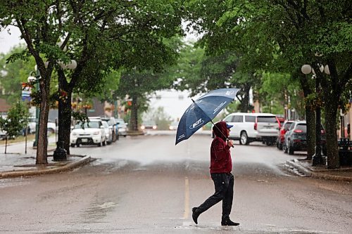 A pedestrian crosses 10th Street in Brandon on a rainy Monday. (Tim Smith/The Brandon Sun)