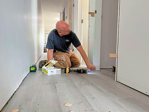 Cancade Restoration's Red seal carpenter Jesse Greenwood checks the level on a closet in a Habitat for Humanity Brandon duplex on Franklin Street. (Michele McDougall/The Brandon Sun)